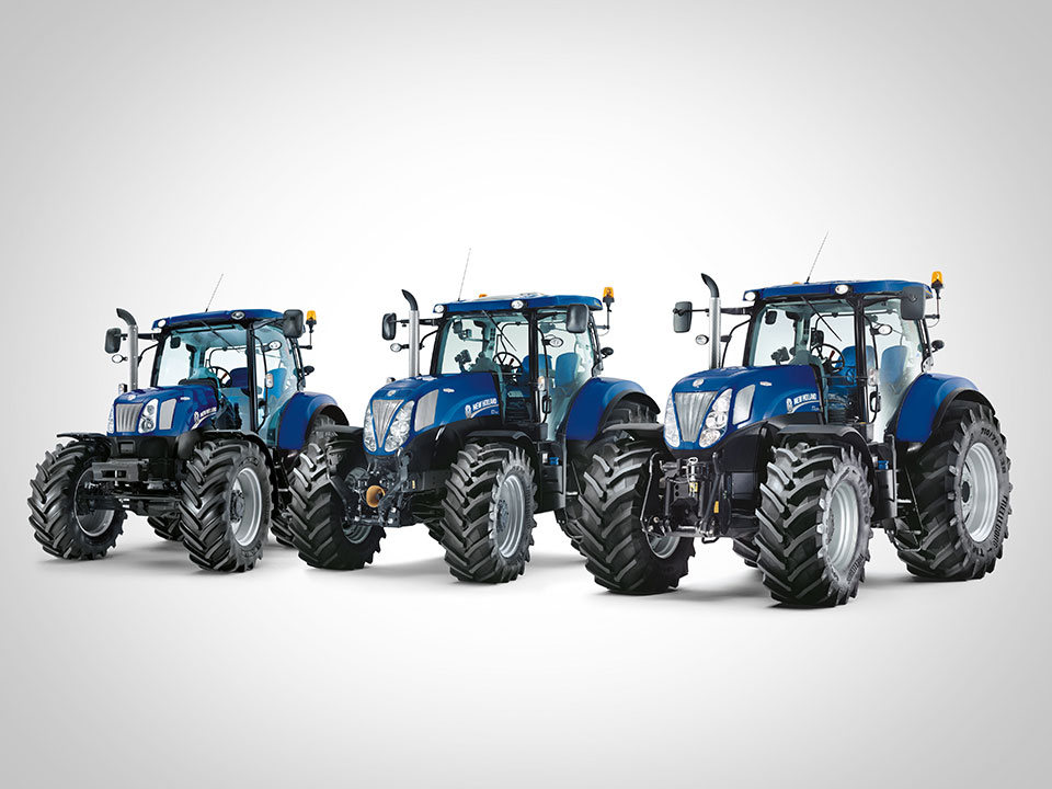 new holland landtechnik blaue landmaschinen traktoren nebeneinander auf grauem hintergrund