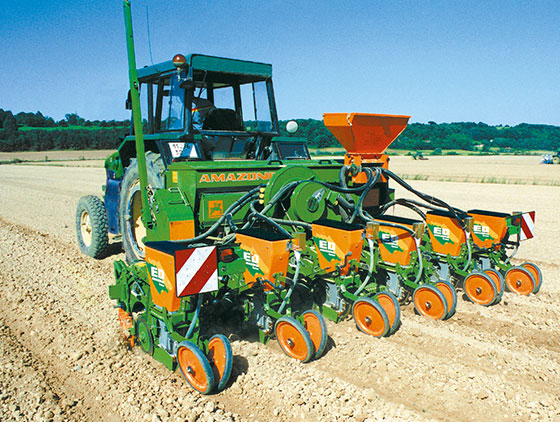 amazone einzelkorn sätechnik hinter traktor auf trockenem feld mir hügeln und blauer himmel