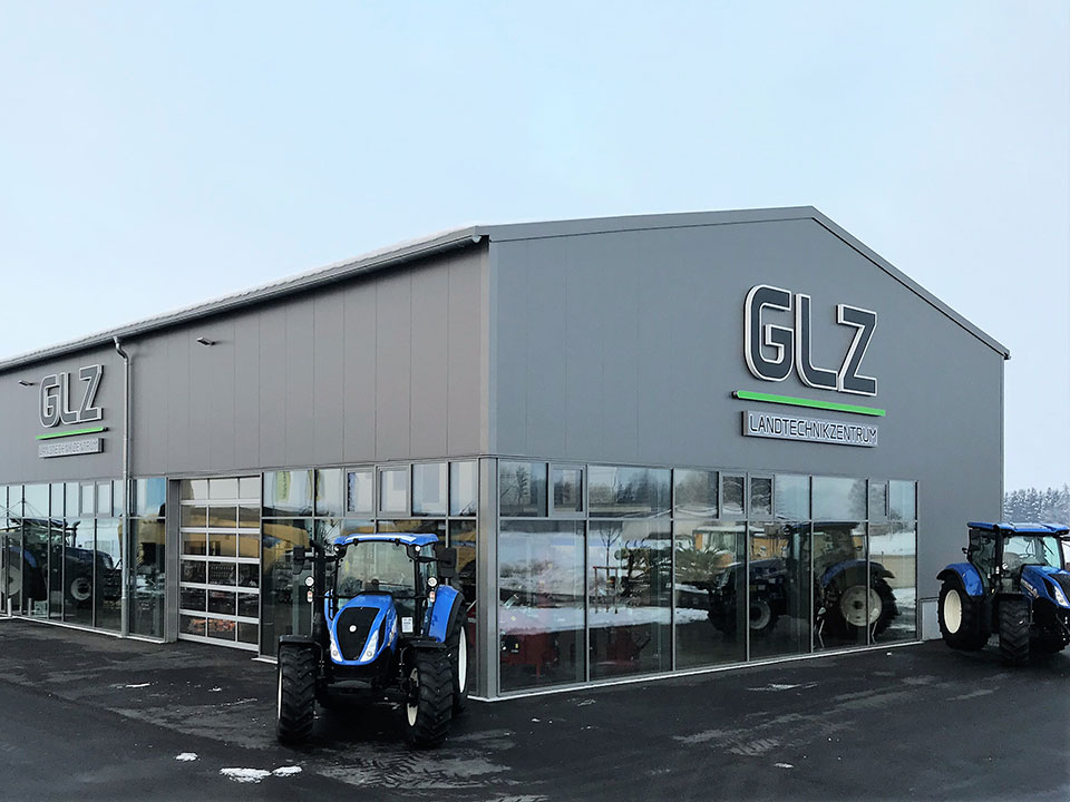 GLZ Egg Landtechnikzentrum 8 glz gebäude mit logo zwei blaue traktoren blauer himmel